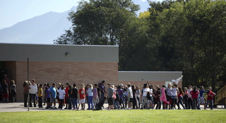 Students line up to go back inside after recess at Westbrook Elementary School in Taylorsville, Utah, on Sept. 11, 2014. Earlier in the day, schoolteacher Michelle Montgomery was injured by fragments from a bullet and a porcelain toilet when her gun accidentally went off in a faculty bathroom.