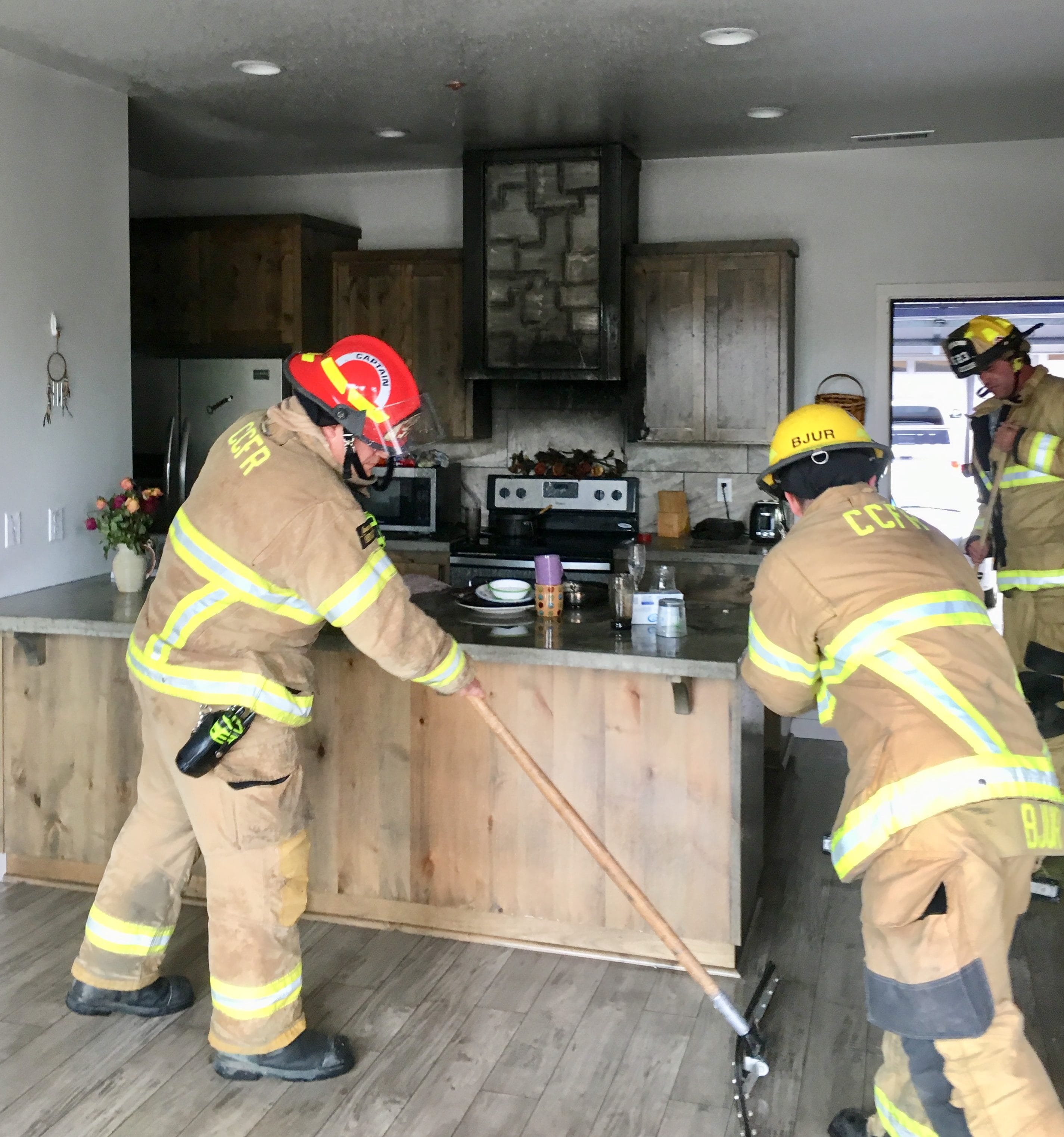 Firefighters clean up after a cooking fire Thursday morning at a Ridgefield condominium. The blaze was contained by a fire sprinkler system.