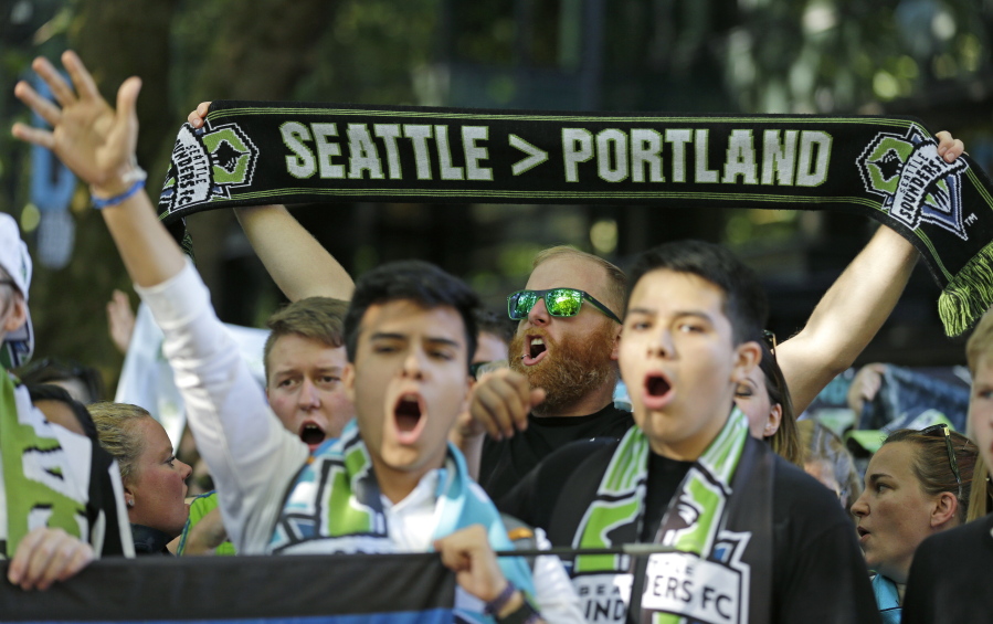 FILE - In this Aug. 27, 2017, file photo, a Seattle Sounders supporter holds up a scarf as he takes part in the traditional March to the Match before an MLS soccer match against the Portland Timbers in Seattle. The Timbers host the Sounders on Sunday in the 100th meeting between the two rivals from the Pacific Northwest. (AP Photo/Ted S.