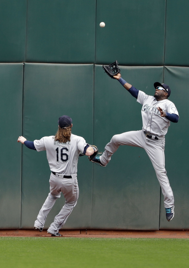 Seattle Mariners center fielder Guillermo Heredia, right, leaps but can’t catch a line drive from Oakland Athletics’ Stephen Piscotty during the first inning of a baseball game Thursday, May 24, 2018, in Oakland, Calif. Piscotty drove in two runs with a double on the play.
