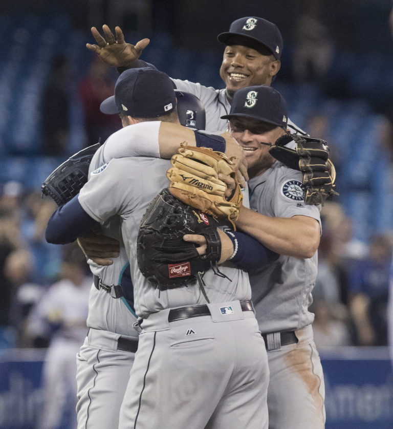 Seattle Mariners starting pitcher James Paxton, back to camera, is mobbed by teammates after throwing a no-hitter against the Toronto Blue Jays in a baseball game Tuesday, May 8, 2018, in Toronto.