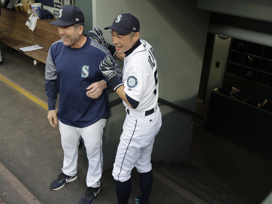 Seattle Mariners’ Ichiro Suzuki, right, laughs with hitting coach Edgar Martinez as Suzuki prepares to exit the dugout before Thursday’s game against the Oakland Athletics. Suzuki was released Thursday by the Mariners and is shifting into a front office role with the team, so he cannot be in the dugout while the game is being played. (Ted S.