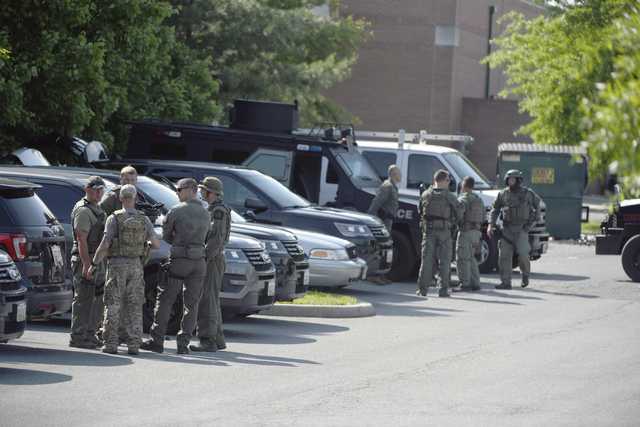 Tactical police stage in a Safeway parking lot on Belair Road near Chapel Road in response to the death of a Baltimore County police officer in Perry Hall, Md., May 21, 2018. Rifle-toting police swarmed into the Baltimore suburb where a female officer was fatally injured Monday, searching for suspects believed to be armed after witnesses reported hearing a pop and seeing the officer run over by a Jeep.