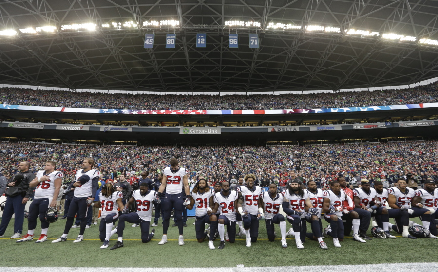Houston Texans players kneel and stand during the singing of the national anthem before an NFL football game against the Seattle Seahawks, in Seattle. NFL owners have approved a new policy aimed at addressing the firestorm over national anthem protests, permitting players to stay in the locker room during the “The Star-Spangled Banner” but requiring them to stand if they come to the field. The decision was announced Wednesday, May 23, 2018, by NFL Commissioner Roger Goodell during the league’s spring meeting in Atlanta.