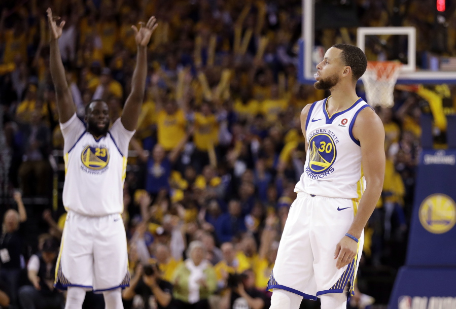 Golden State Warriors' Draymond Green, left, raises his arms in celebration after a 3-point basket by teammate Stephen Curry (30) during the second half in Game 5 of an NBA basketball second-round playoff series against the New Orleans Pelicans Tuesday, May 8, 2018, in Oakland, Calif.