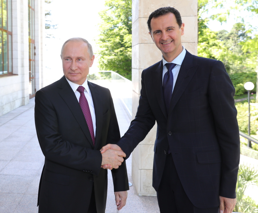 Russian President Vladimir Putin, left, shakes hands with Syrian President Bashar al-Assad during their meeting in the Black Sea resort of Sochi, Russia, Thursday.