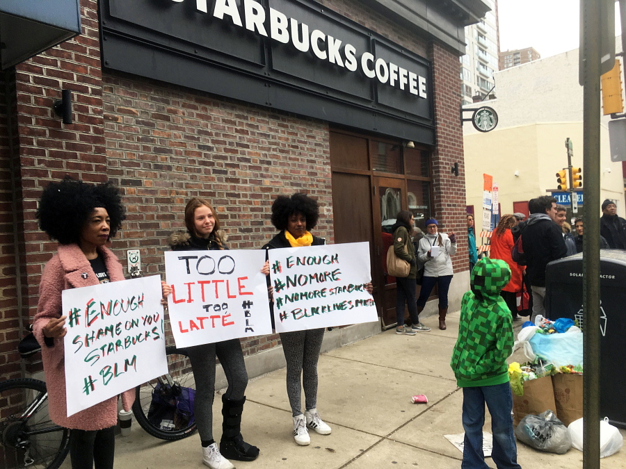 Demonstrators protest April 15 outside the Starbucks cafe in Philadelphia where two black men were arrested three days earlier for waiting inside without ordering anything.