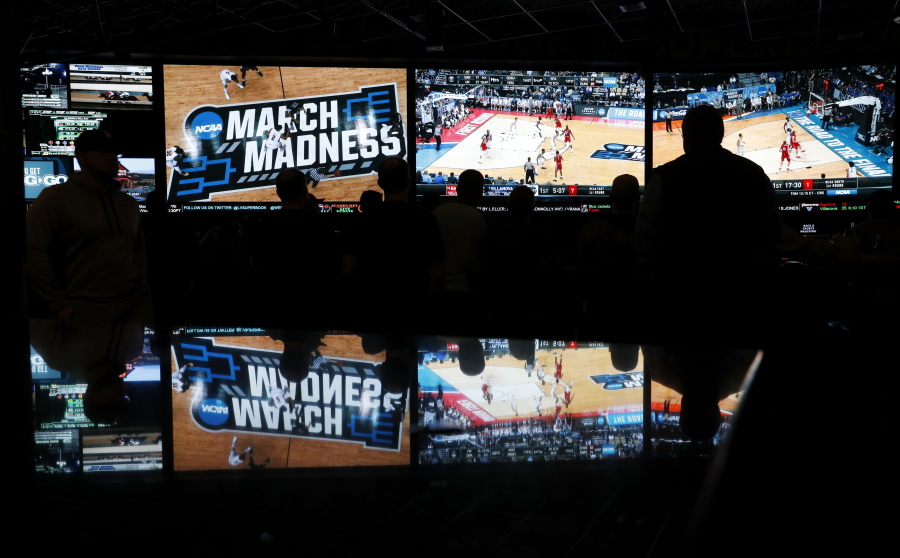 In this March 15, 2018 photo, people watch coverage of the first round of the NCAA college basketball tournament at the Westgate Superbook sports book in Las Vegas.