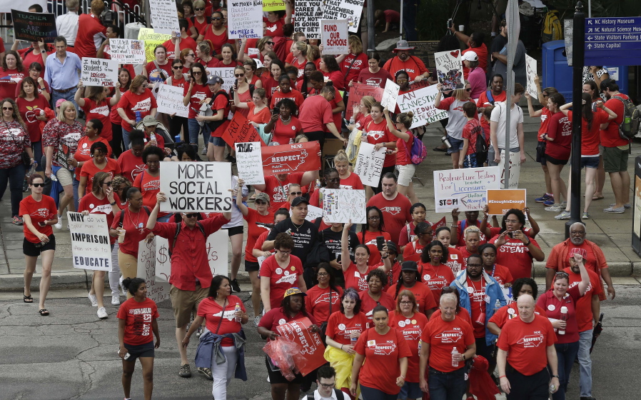Participants make their way towards the Legislative Building during a teacher’s rally at the General Assembly in Raleigh, N.C., on Wednesday. Thousands of teachers rallied the state capital seeking a political showdown over wages and funding for public school classrooms.