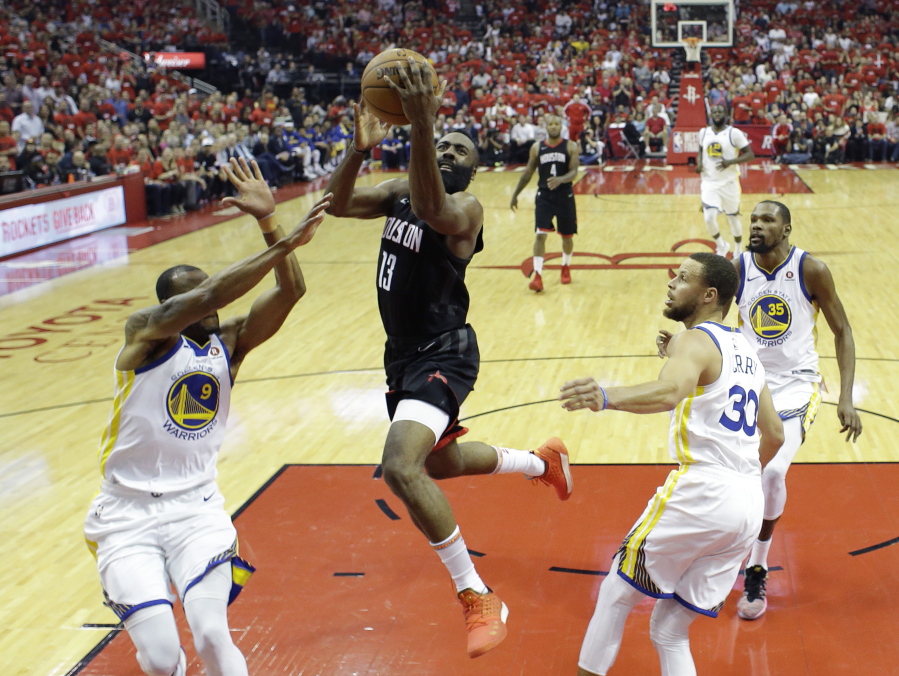 Houston Rockets guard James Harden (13) drives to the basket past Golden State Warriors defenders Andre Iguodala (9), Stephen Curry (30), and Kevin Durant (35) during the first half in Game 2 of the NBA basketball Western Conference Finals, Wednesday, May 16, 2018, in Houston. (AP Photo/David J.