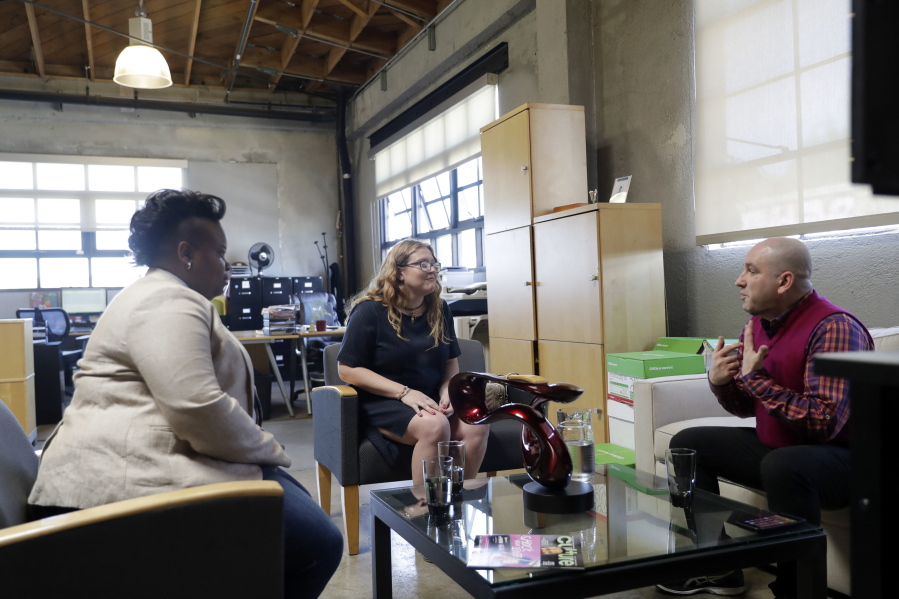 In this May 11, 2018, photo, Danielle Schumacher, center, CEO and Co-Founder of THC Staffing Group talks to fellow entrepreneurs Etienne Fontan, right, Director of Berkeley Patients Group and Amber Senter, CEO of Leisure Life in Berkeley, Calif. Women have made inroads in the male-dominated cannabis business. But they still face a so-called grass ceiling as the industry grows and becomes more mainstream.