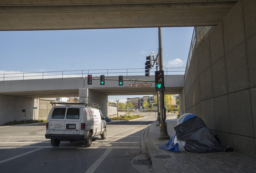 A motorist passes the tent of a homeless resident along an overpass on Grant Street in Vancouver in April.