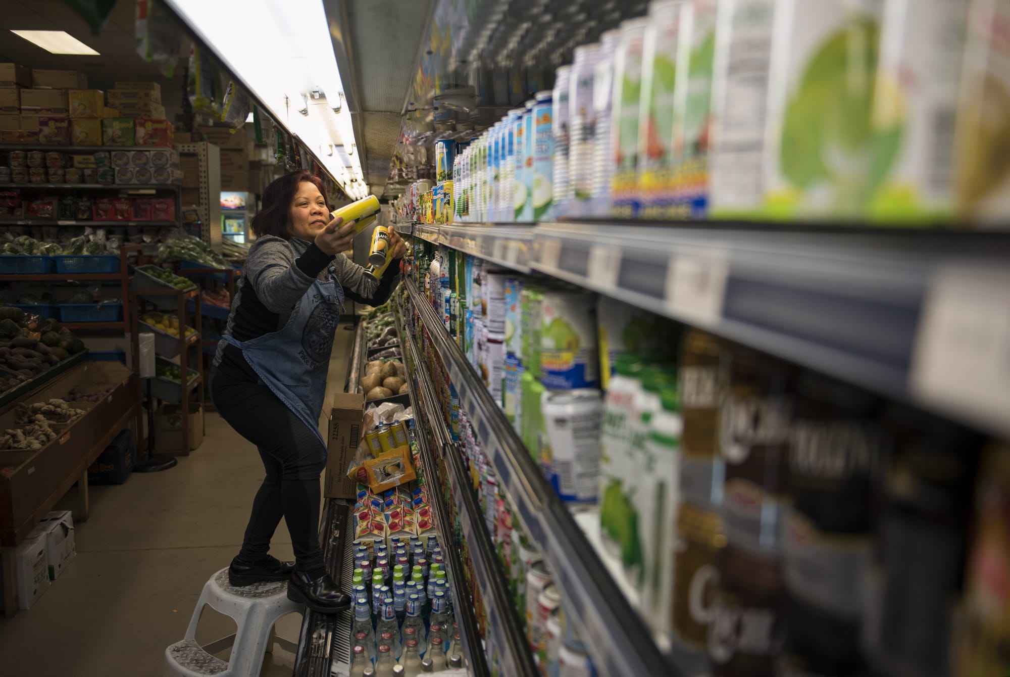 Vongxay Kikdavong of Vancouver, originally from Laos, stocks the shelves with mango juice and coconut water at Tola Angkor Asian Market in Vancouver in January.