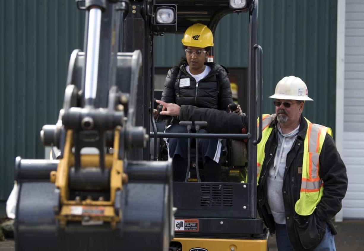Mountain View High School junior Danayt Tewelde learns how to operate excavator controls with help from Jerry Hollor of Ridgefield during the Youth Employment Summit at Clark County Event Center in April. Outreach like the annual summit offers opportunities to help young adults in need of secondary education.