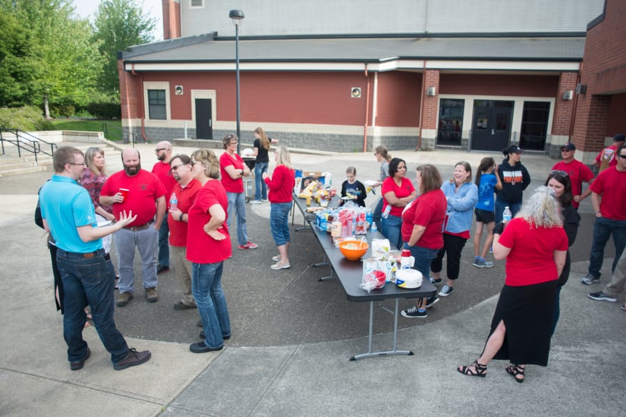 Members of the Washougal Association of Educators chat while waiting to hear updates from their contract negotiations with the school district at Washougal High School in June. The Washougal Association of Educators held a tailgate outside the high school during the negotiations.