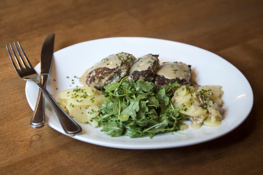 The Bavarian Meatballs served with German potato salad and fresh greens at Gustav’s in Vancouver.