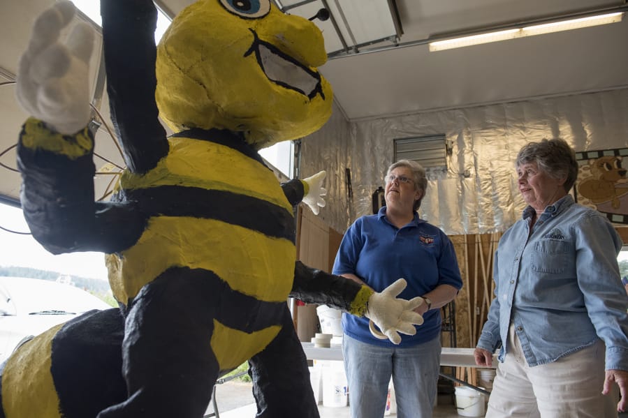 Barbara Rowe, center, and Pat Stanfield pause to consider the big bee they’re preparing for Battle Ground´s Rose Festival Parade float on Monday. Battle Ground volunteers have built a float for the Grand Floral Parade annually since 1955. This year was the first time the effort appeared to be in doubt.