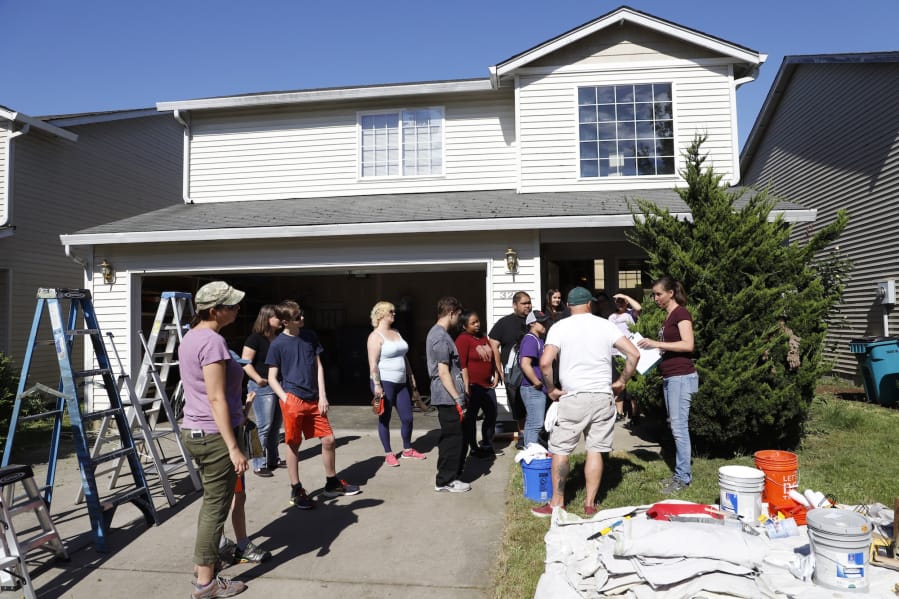 Volunteers with Michelle’s Love, a small nonprofit that helps single moms with cancer, did yard work, cleaned and painted the inside of Christy Castro’s house in Vancouver on Saturday.