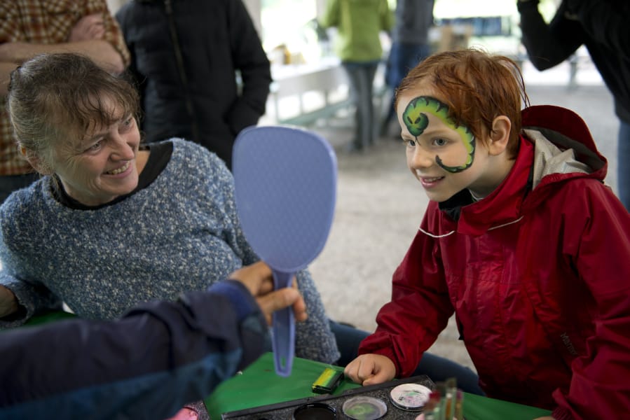 Owen Becker-Nunley, 6, of North Bonneville, gets a snake painted on his face by artist June Halliday of JJ Entertainers of Portland. Face painting was one of a handful of activities at booths, most of which were educational, at the Run Wild Nature Adventures Family Fun Day on Sunday in Camas.