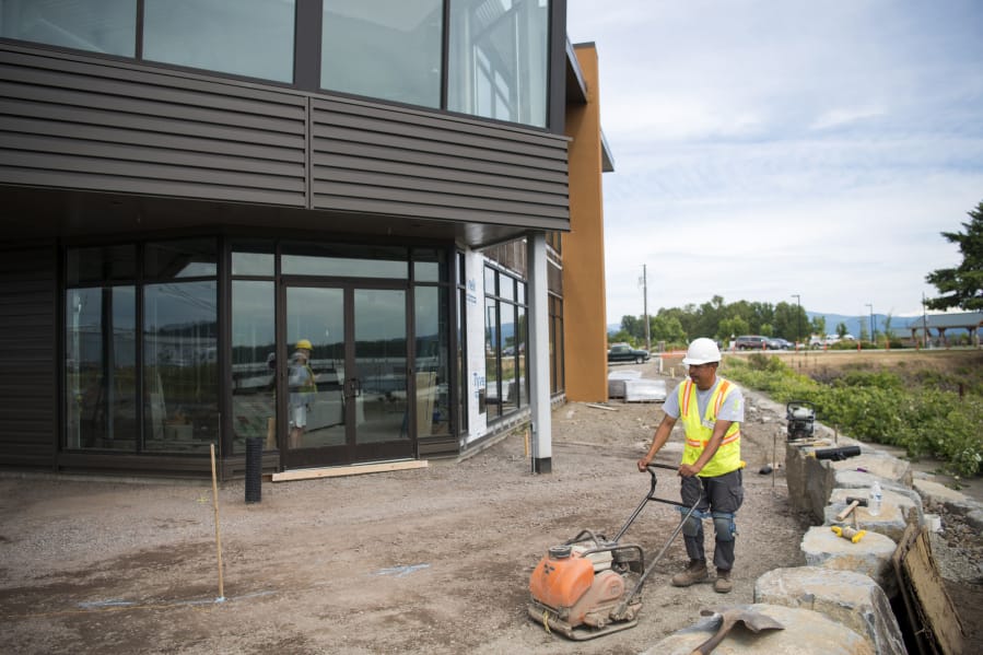 Efren Martinez Zavala with GRO Outdoor Living works on the outdoor patio outside The Black Pearl in Washougal. The long-unused building is expected to open as an events center in August.