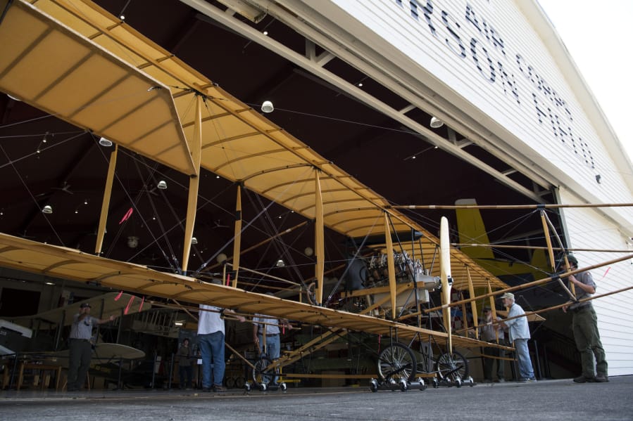 Plane builders and Fort Vancouver staff members ease the Curtiss Pusher into the Pearson Air Museum at Fort Vancouver National Historic Site on Tuesday.
