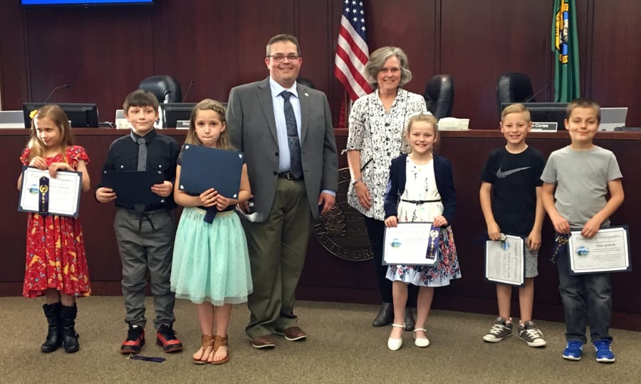 Battle Ground: Tukes Valley second-graders were honored by Battle Ground Mayor Mike Dalesandro, back row from left, and Battle Ground Art Alliance President Dotty Yackle-Kay for their artwork depicting Community Helpers, which was hanging in city hall. From left: Celia Cavens, Karson Win’E, Ella Antonov, Stella Potter, Lincoln Toland and Tim Didyk.