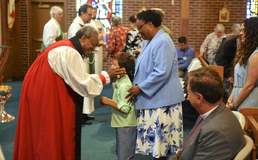 The Most Rev. Michael Curry, left, administers communion to Andrew Coxcollins and Lisa Collins at St. Luke’s Episcopal Church in Vancouver on Sunday. Curry, as presiding bishop and primate of the Episcopal Church of the United States, is the leader of the church’s clergy.