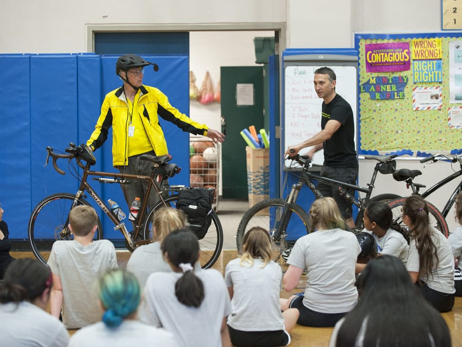Joe Greulich, left, and Peter Van Tilburg of Bike Clark County offer biking advice to students in the gym at Discovery Middle School on Tuesday morning, May 10, 2016.