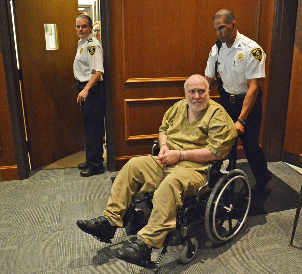 A court officer pushes convicted child rapist Wayne Chapman in the court room at his arraignment on Wednesday, June 6, 2018, in Ayer, Mass. Chapman, who was set to be released from custody after two experts concluded he was no longer "sexually dangerous" will remain locked up after he was arrested Wednesday for indecent exposure and lewd acts, authorities said.
