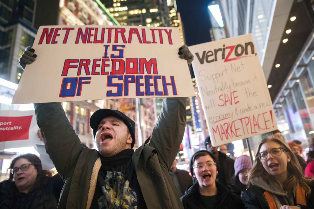 FILE - In this Thursday, Dec. 7, 2017 file photo, Demonstrators rally in support of net neutrality outside a Verizon store in New York. Consumers aren’t likely to see immediate changes following Monday, June 11, 2018 formal repeal of Obama-era internet rules that had ensured equal treatment for all. Rather, any changes are likely to happen slowly, and companies will try to make sure that consumers are on board with the moves, experts say.