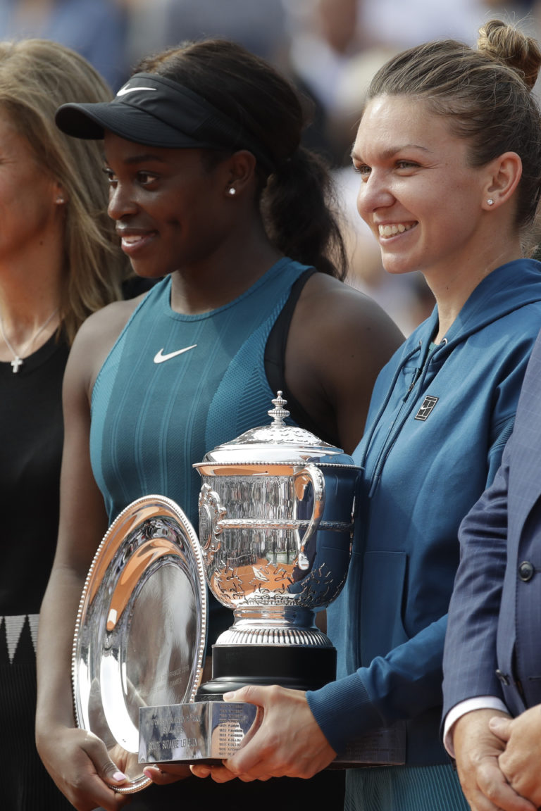Romania's Simona Halep, right, holds the trophy as she poses with runner-up Sloane Stephens of the U.S. after winning the final match of the French Open tennis tournament against Sloane Stephens of the U.S. in three sets 3-6, 6-4, 6-1, at the Roland Garros stadium in Paris, France, Saturday, June 9, 2018.