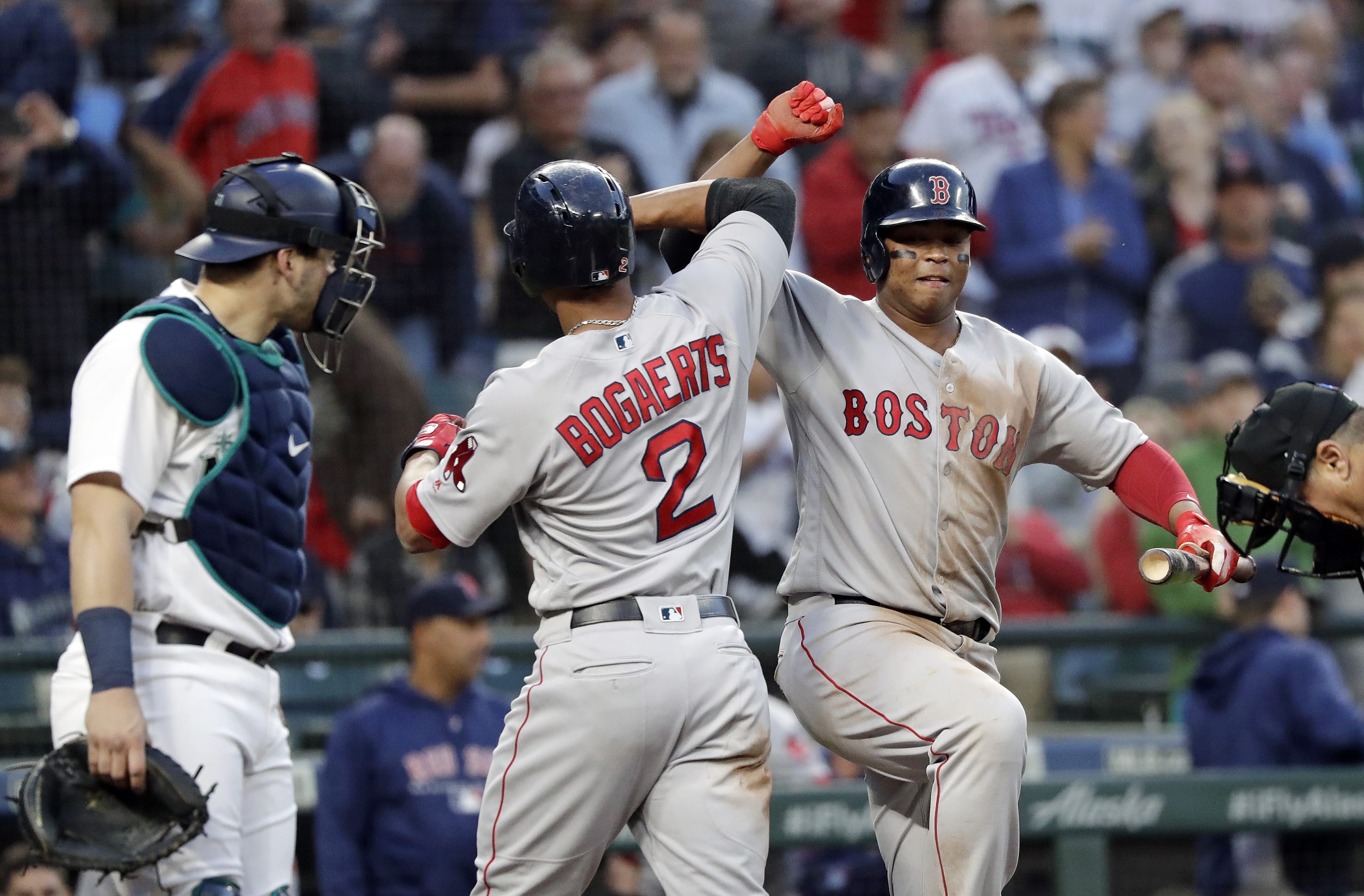 Boston Red Sox's Xander Bogaerts (2) is congratulated on his solo home run by Rafael Devers as Seattle Mariners catcher Mike Zunino stands nearby during the sixth inning of a baseball game Thursday, June 14, 2018, in Seattle.