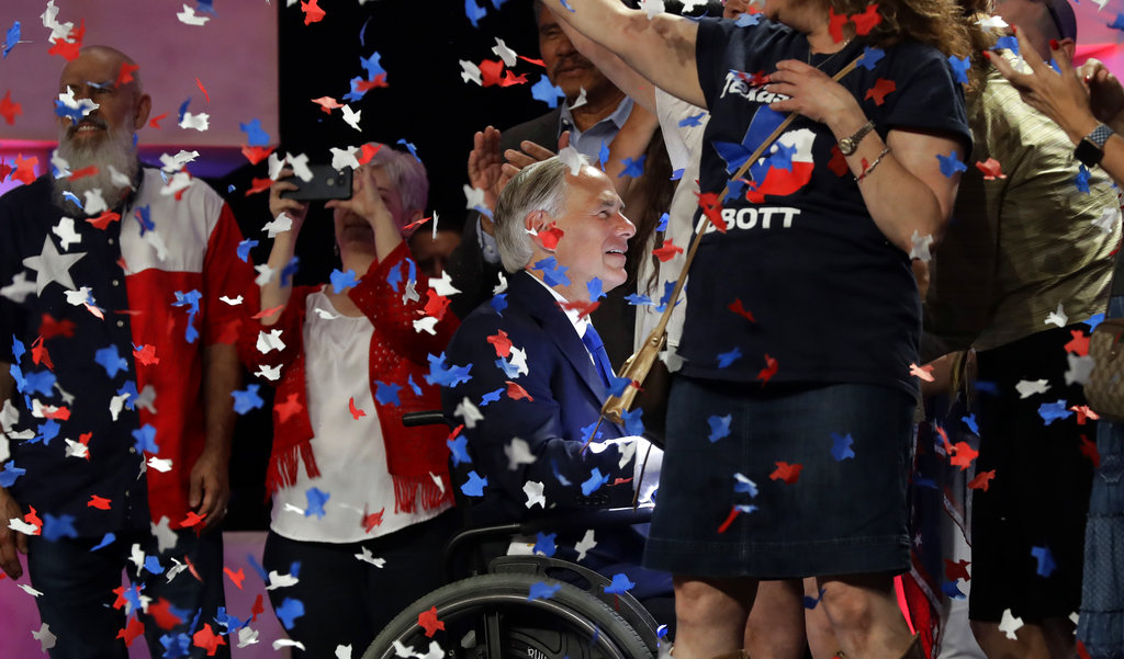 Confetti falls as Texas Gov. Greg Abbott, center, greets supporters after speaking at the Texas GOP Convention, Friday, June 15, 2018, in San Antonio.
