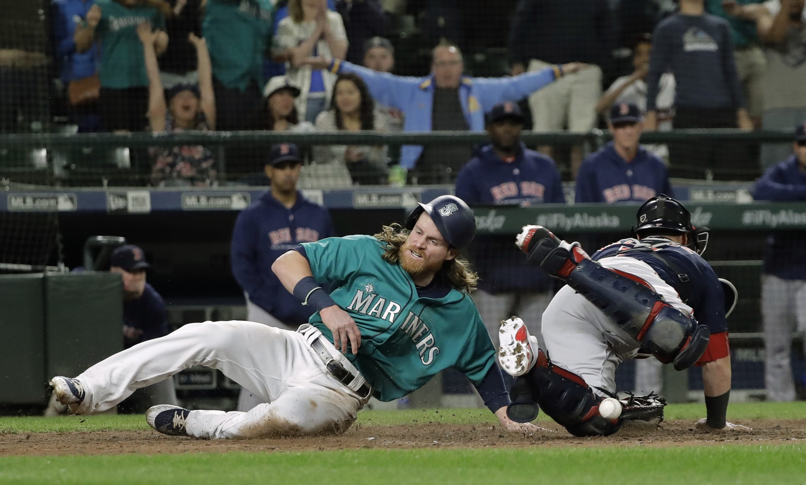 Seattle Mariners' Ben Gamel, left, scores as Boston Red Sox catcher Sandy Leon can't hold on to the ball during the eighth inning of a baseball game Friday, June 15, 2018, in Seattle. Gamel scored on a go-ahead two-run double by Denard Span. The Mariners won 7-6. (AP Photo/Ted S.