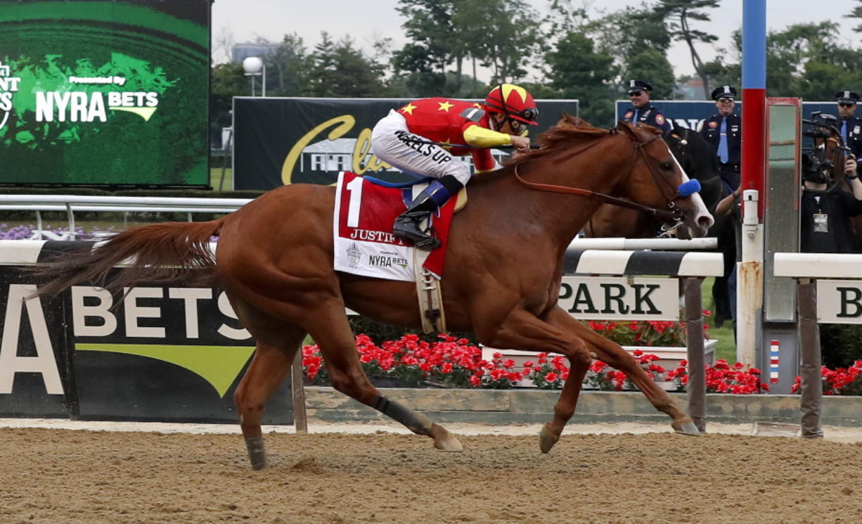 Justify (1), with jockey Mike Smith up, crosses the finish line to win the 150th running of the Belmont Stakes horse race, Saturday, June 9, 2018, in Elmont, N.Y.