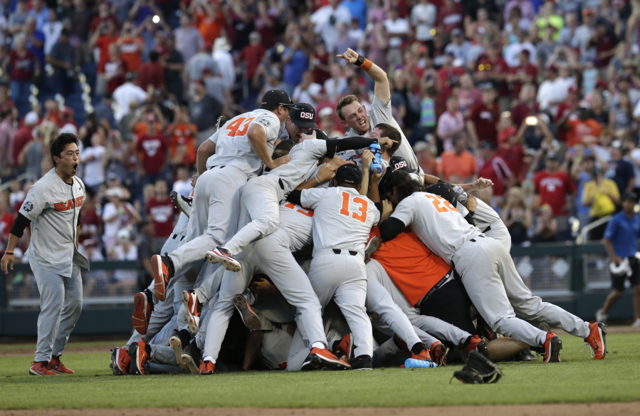 Oregon State players celebrate after they beat Arkansas 5-0 in Game 3 to win the NCAA College World Series baseball finals, Thursday, June 28, 2018, in Omaha, Neb.