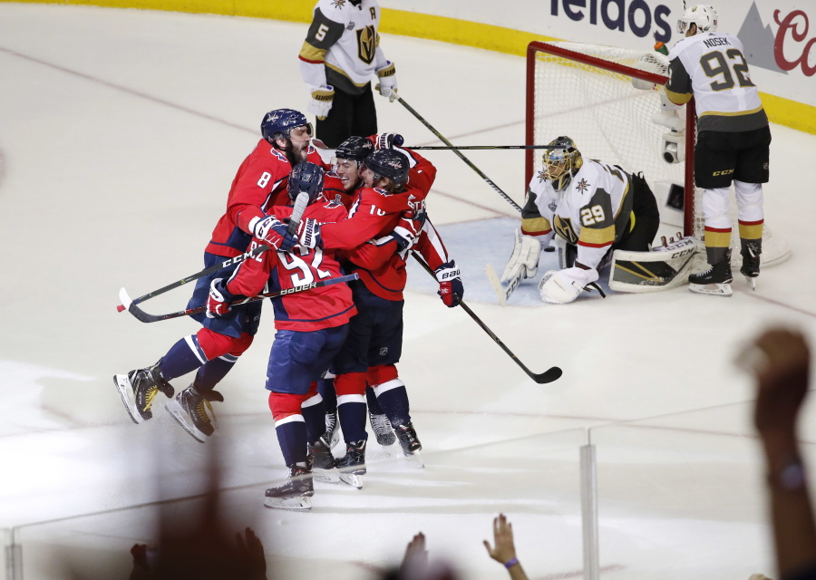 Teammates celebrate with Washington Capitals forward T.J. Oshie, center of the huddle, who scored a goal past Vegas Golden Knights goaltender Marc-Andre Fleury (29) during the first period in Game 4 of the NHL hockey Stanley Cup Final, Monday, June 4, 2018, in Washington.