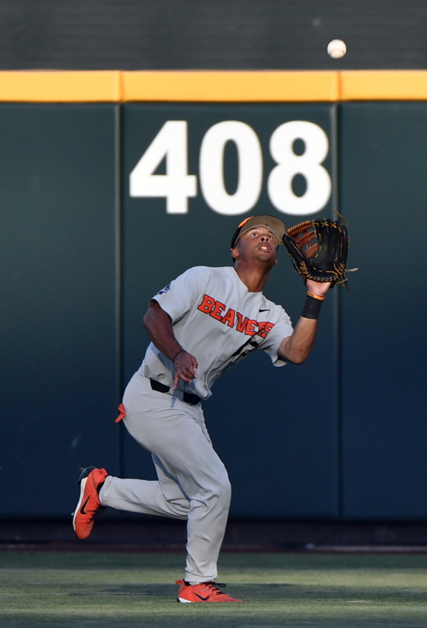 Oregon State's Preston Jones, from Vancouver, chases down a fly ball hit by Arkansas' Heston Kjerstad during the sixth inning in Game 3 of the NCAA College World Series baseball finals in Omaha, Neb., Thursday, June 28, 2018.