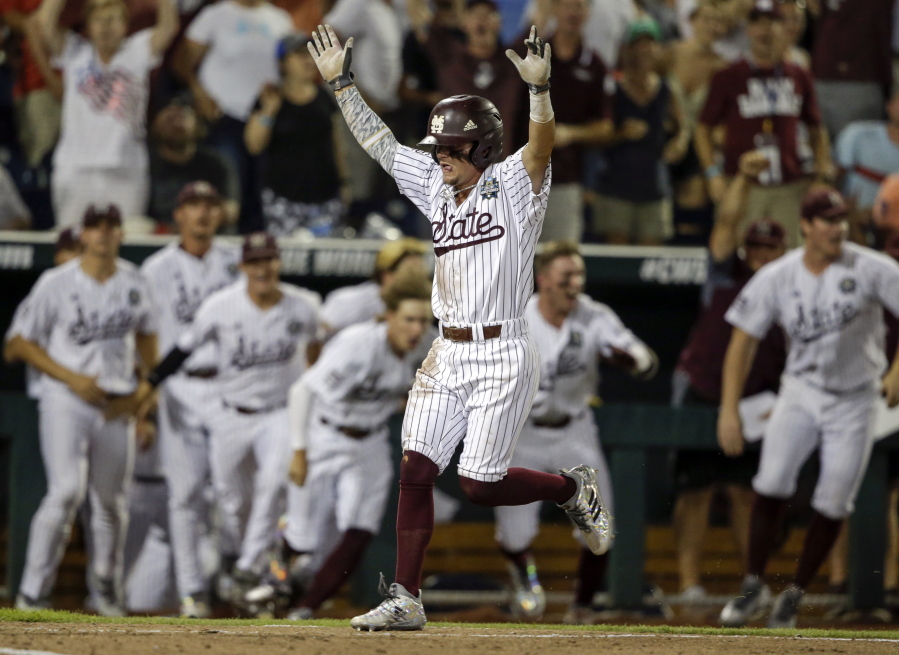 Mississippi State’s Hunter Stovall, center, celebrates as he runs to home plate for the winning run against Washington on a single by Luke Alexander in the ninth inning of an NCAA College World Series baseball game in Omaha, Neb., Saturday, June 16, 2018.