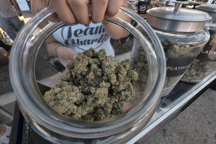 A vendor shows one of an assortment of marijuana strains during the High Times Harvest Cup in San Bernardino, Calif., Nov. 11, 2017. Several marijuana businesses in California warned Friday that they could face steep financial losses unless the state extends a July 1 deadline imposing strict standards for pot testing and packaging.