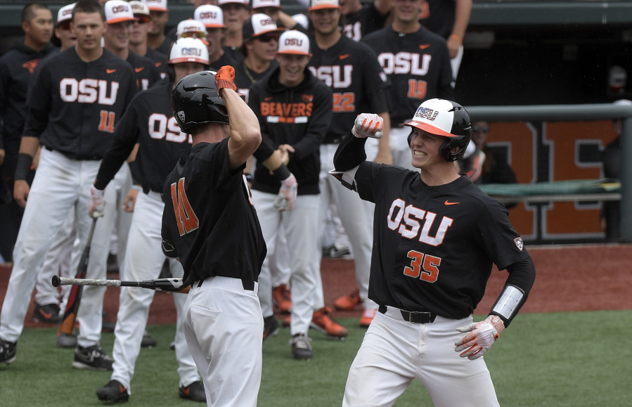 Oregon State’s Adley Rutschman (35) celebrates with Micahel Gretler (10) after hitting a solo home run in the first inning against Minnesota on Friday in Corvallis, Ore.
