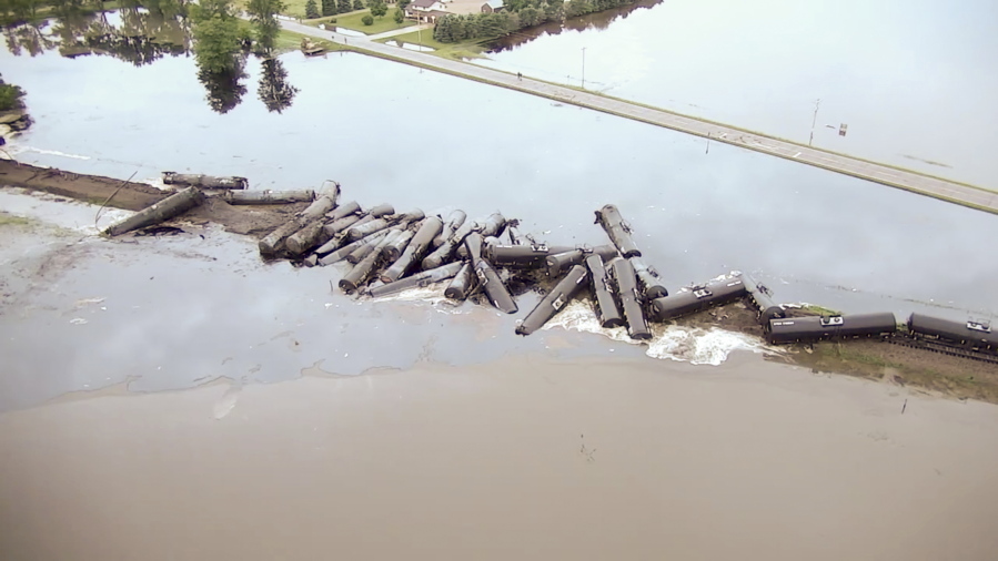 In this aerial drone image, tanker cars carrying crude oil are shown derailed Friday about a mile south of Doon, Iowa. About 33 cars derailed after the tracks reportedly collapsed due to saturation from floodwaters from adjacent Little Rock River.