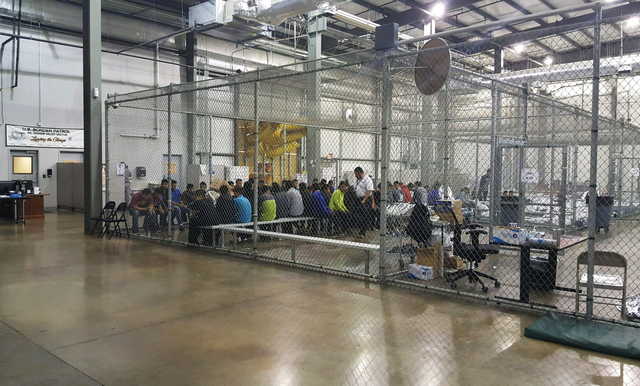 In this photo provided by U.S. Customs and Border Protection, people who've been taken into custody related to cases of illegal entry into the United States, sit in one of the cages at a facility in McAllen, Texas, Sunday, June 17, 2018. (U.S.