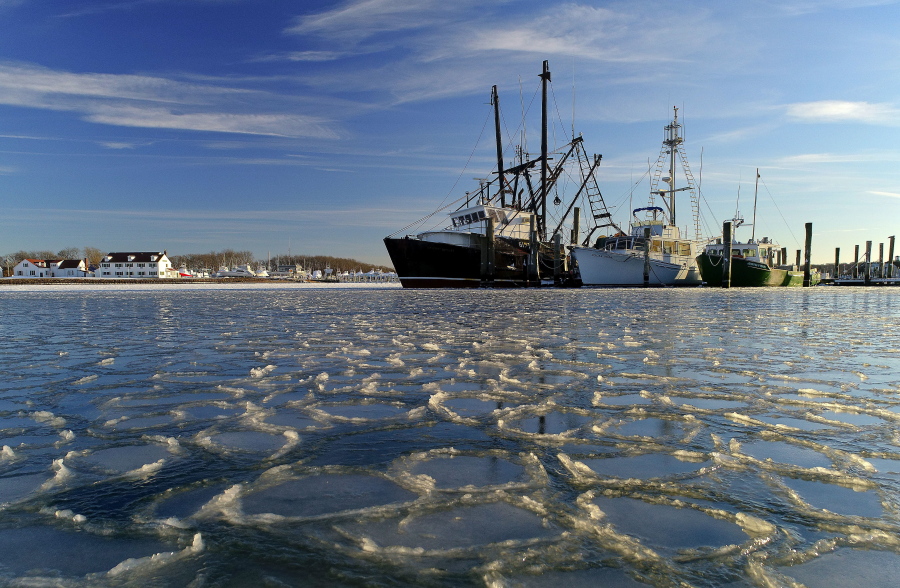 Surrounded by ice, commercial fishing boats are docked in their slips after more than a week’s worth of frigid weather froze the harbor in Lake Montauk in Montauk, N.Y., on Sunday, Jan. 7, 2018. Only a few commercial boats remain in Montauk harbor during the winter months fishing for species such as porgy, tilefish, monkfish and black sea bass.