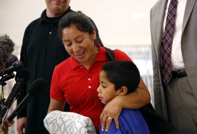 Beata Mariana de Jesus Mejia-Mejia, left, embraces her son Darwin Micheal Mejia as she speaks at a news conference following their reunion at Baltimore-Washington International Thurgood Marshall Airport, Friday, June 22, 2018, in Linthicum, Md. The Justice Department agreed to release Mejia-Mejia's son after she sued the U.S. government in order to be reunited following their separation at the U.S. border. She has filed for political asylum in the U.S. following a trek from Guatemala.