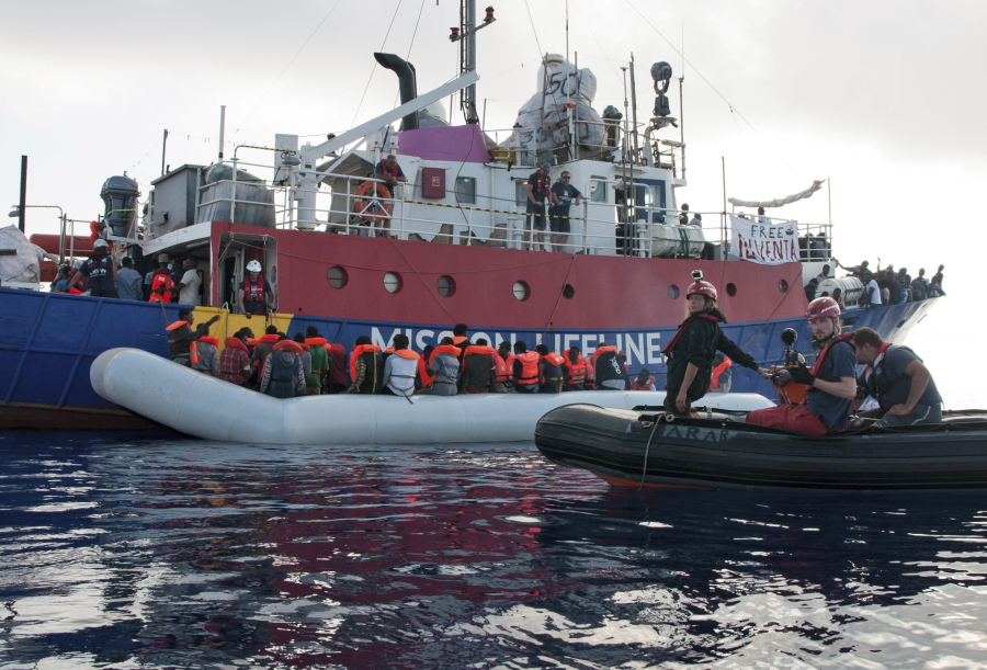 A ship operated by the German NGO Mission Lifeline rescues migrants from a rubber boat Thursday in the Mediterranean Sea off of the Libyan coast.