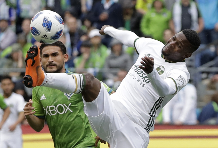 Portland Timbers midfielder Dairon Asprilla, right, kicks the ball in front of Seattle Sounders midfielder Cristian Roldan, left, during the first half of an MLS soccer match, Saturday, June 30, 2018, in Seattle. (AP Photo/Ted S.