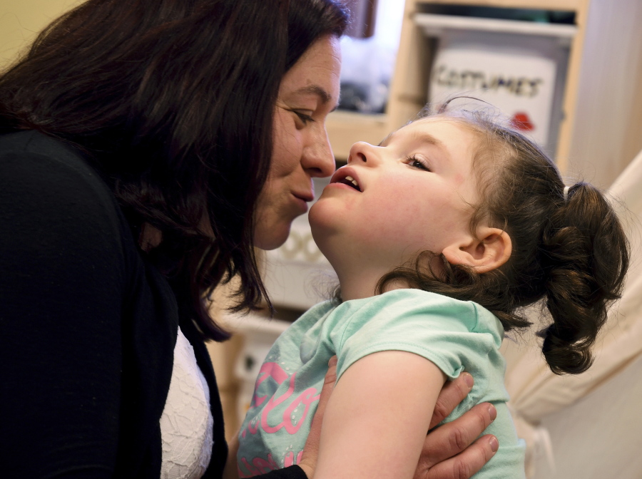 Meagan Patrick kisses her daughter, Addelyn Patrick, 5, in the playroom at Realm of Caring in Colorado Springs, Colo. Addelyn was born with a brain malformation and suffers from multiple forms of seizures. The U.S. Food and Drug Administration is expected to decide soon whether to give its first approval to a prescription drug made from the marijuana plant. But parents, including Meagan, who have used other products containing chemicals from the plant to treat their children’s severe forms of epilepsy are feeling more cautious than celebratory.
