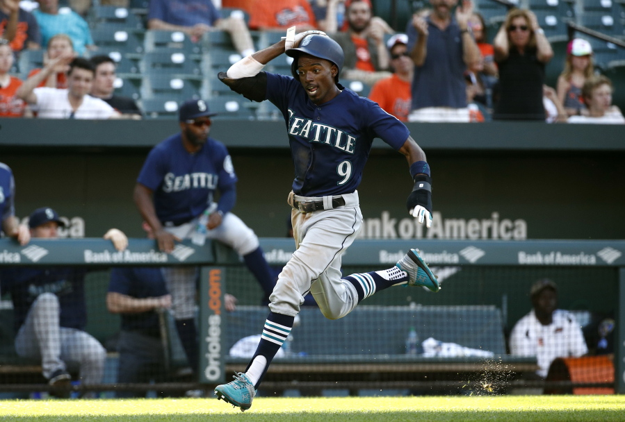 Seattle Mariners’ Dee Gordon scores a run on a single by Jean Segura in the 10th inning against the Baltimore Orioles, Thursday. Seattle won 4-2 in 10 innings.