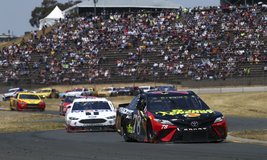 Martin Truex Jr. (78) leads Kevin Harvick (4) through a turn during a NASCAR Sprint Cup Series auto race Sunday, June 24, 2018, in Sonoma, Calif.